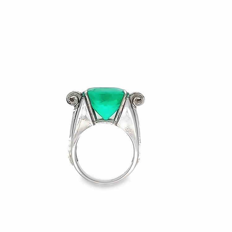 Close-up view of the side of the ring standing up. Side view of the emerald gemstone and gold detailing.