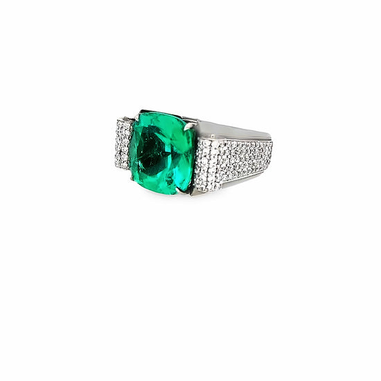 Side view of the cushion cut emerald ring. This angle showcases the 1.41 carats of radiant-cut white diamonds set on the side of the ring band. 
