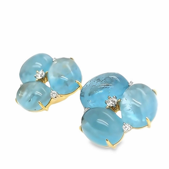 Close up of the Verdura stud earrings, featuring a cluster of blue aquamarine gemstones and round white diamonds set in 18k yellow gold and platinum.