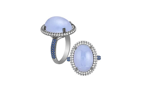 Oval blue chalcedony ring adorned with white diamonds and blue sapphires set on 18K white gold with light black rhodium