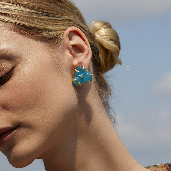 Image of a woman wearing the aquamarine and diamond verdura earrings. 
