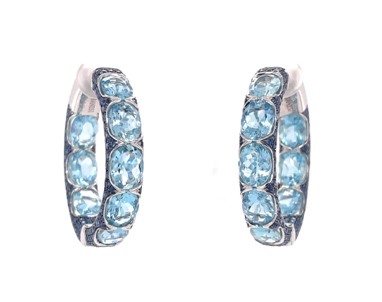 Close up view of the Aquamarine Hoop Earrings. Featuring oval aquamarine gemstones and small round blue sapphire gemstones set in 18k white gold. 
