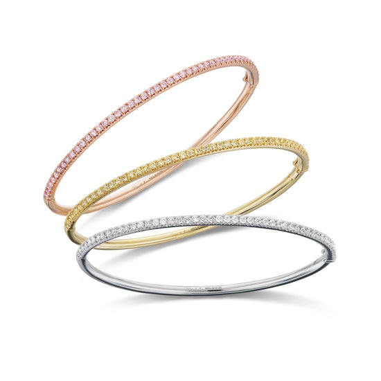 Set of cuff bracelets in rose gold with pink diamonds, yellow gold with yellow diamonds, and white gold with white diamonds